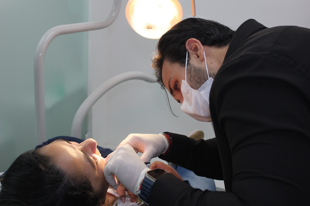 Dentista realizando atendimento em paciente no consultório